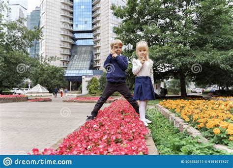 Enfants Qui Jouaient Dans Le Parc De La Ville En Regardant Les Fleurs