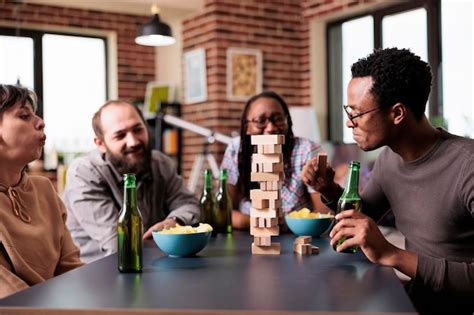 Premium Photo Multiethnic Group Of Friends Sitting At Table In Living