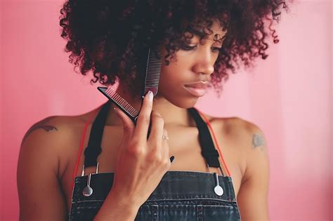 Premium Photo African American Hairdresser Woman Holding A Comb And