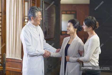 Chinese Doctor Shaking Hands With Patients In Hospital Hall Asian Ethnicity Mature Man