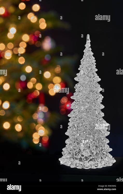 Crystal Glass Christmas Tree In Front Of A Real Christmas Decorated With Multicolored Lights