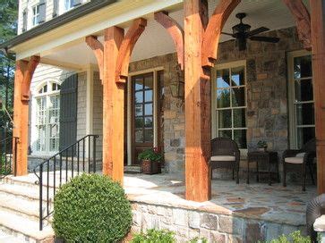 the front porch is covered with wooden pillars