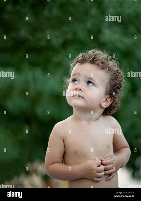 Beautiful Baby With Curly Hair In The Garden Without T Shirt Stock