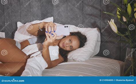 Attractive Woman Taking Selfie On Her Smartphone While Lying On Bed In Hotel Stock Image Image