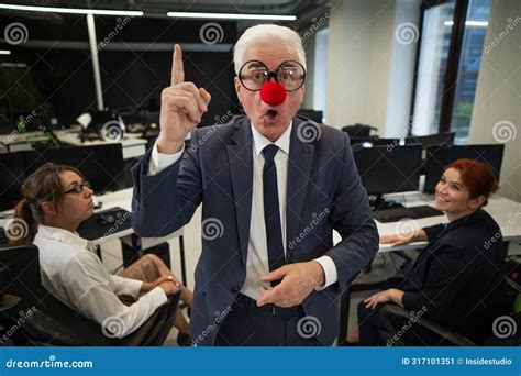 An Elderly Man In A Clown Costume Fools Around At Work Stock Image