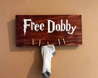 A Wooden Sign That Says Free Dobby Hanging From A Clothes Line On A Wall