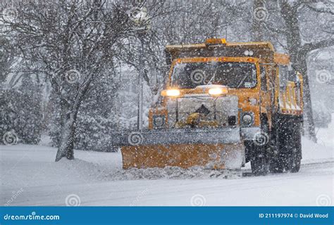 Snow Plow Truck Clearing Icy Road After Winter Snowstorm Blizzard For