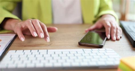 Woman Holding Smartphone And Nervously Tapping Fingers On Table Stock