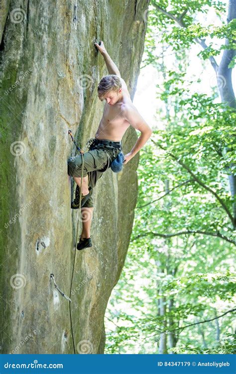 Muscular Rock Climber Climbs On Cliff Wall With Rope Stock Image