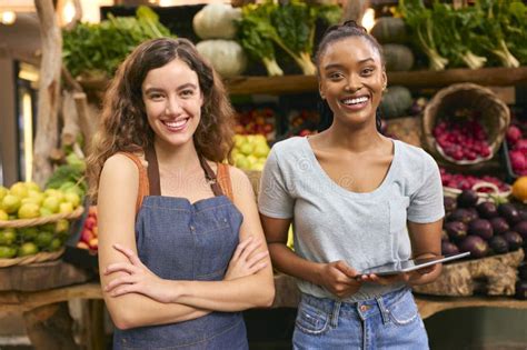 Retrato De Dos Mujeres Sonrientes Con Tableta Digital Trabajando En Un