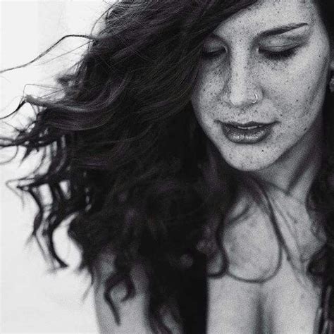 A Black And White Photo Of A Woman With Freckles On Her Hair Looking Down