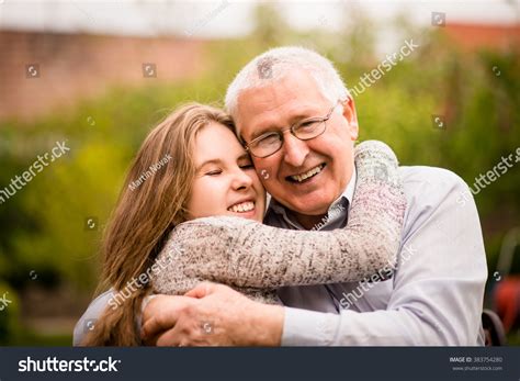 Authentic Photo Of Smiling Grandfather Hugging With His Teenage