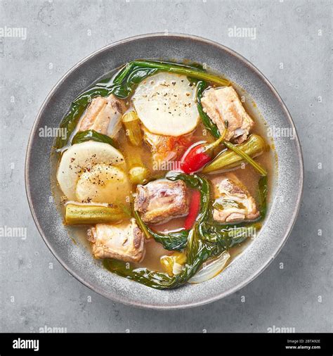 Sinigang Na Baboy Or Filipino Pork Meat Soup In Gray Bowl On Concrete