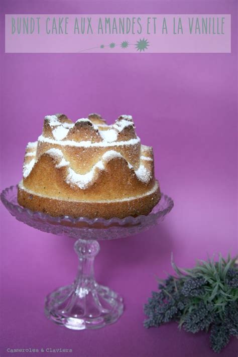 A Bundt Cake With White Icing On A Glass Plate Next To A Potted Plant