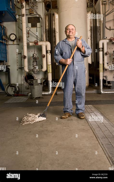 Male Caucasian In Blue Custodianjanitor Overalls In Factory Setting