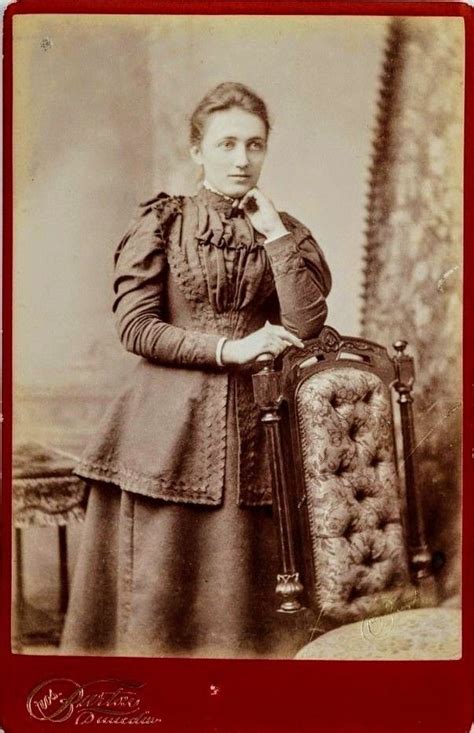 An Old Photo Of A Woman Holding A Chair