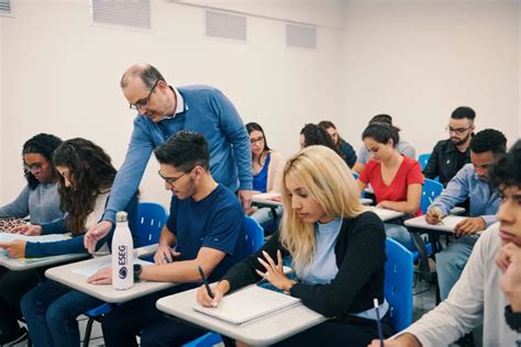 Professor Auxiliando Alunos Durante Uma Aula Na Faculdade ESEG