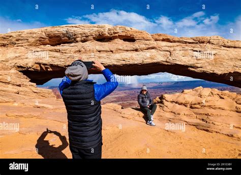 Asian Tourist Photographing His Wife At Mesa Arch Island In The Sky