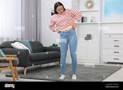 Woman Trying To Put On Tight Jeans At Home Stock Photo Alamy