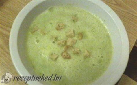 A White Bowl Filled With Soup On Top Of A Wooden Table