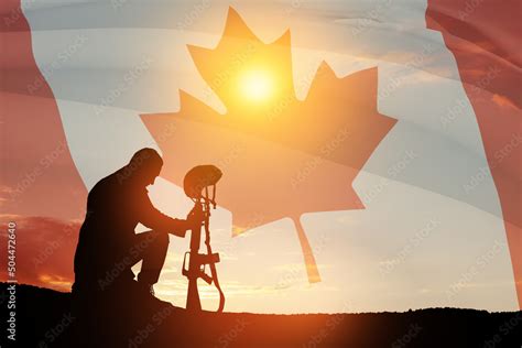 Silhouette Of Soldier Kneeling With His Head Bowed On A Background Of