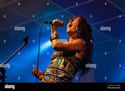 A Female Musician Is Viewed From A Low Angle As She Sings With Open