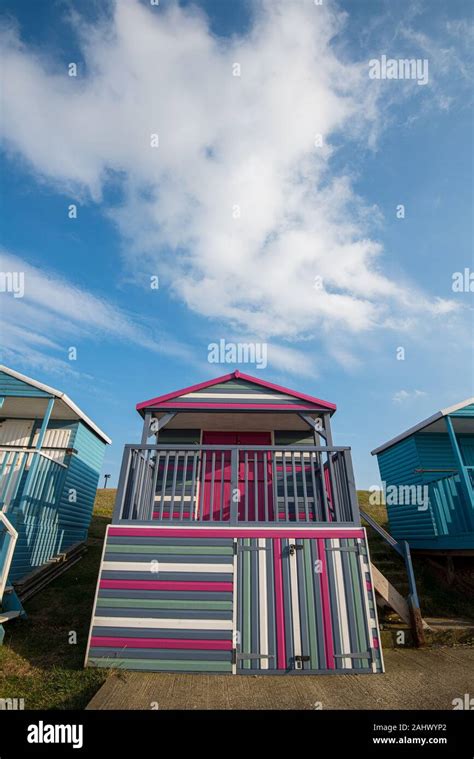 Multi Coloured Holiday Wooden Beach Huts Facing The Ocean On The Beach