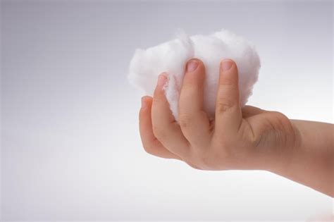 Premium Photo Hand Holding Some Cotton In Hand On A White Background