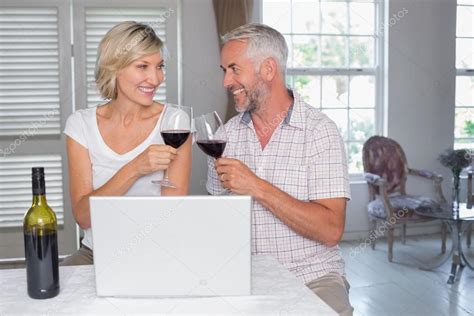 Mature Couple Toasting Wine Glasses At Home Stock Photo