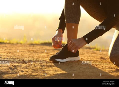 Closeup Of Runner Woman Hands Tying Shoelaces Of Shoes On The Ground At