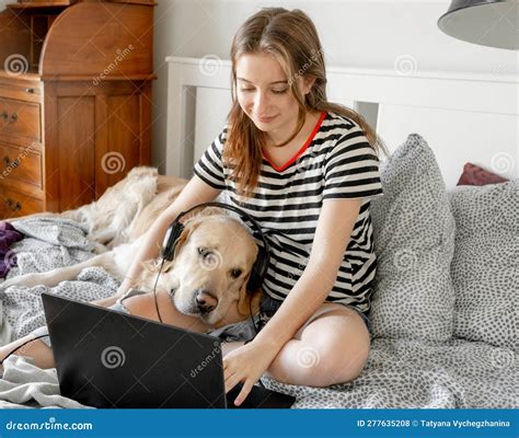 Chica Con Perro Recuperador De Oro En La Cama Foto De Archivo Imagen