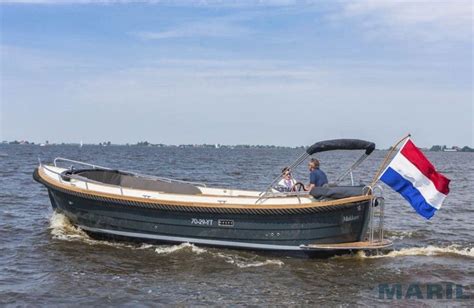 Two People On A Boat With A Flag In The Water