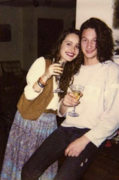 Two People Are Posing For A Photo With Wine Glasses In Their Hands And