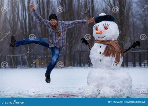 O Homem Feliz Esculpe Um Boneco De Neve Real Grande Foto De Stock