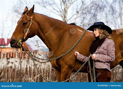 Belle Femme Blonde Chez Un Cheval Se Tenant Prêt De Chapeau Photographie stock Image