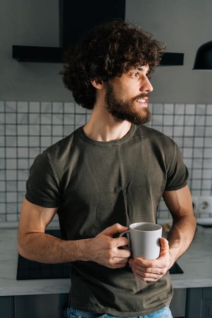 Retrato vertical de um jovem pensativo segurando um copo café da