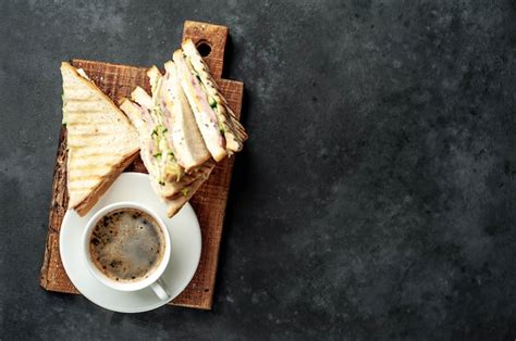 Café y sandwiches con jamón queso tomate lechuga y pan tostado