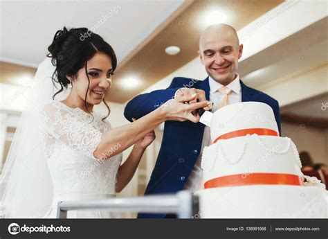 Newlyweds Cutting Wedding Cake Stock Photo By ©olexiysyrotkin 138991668