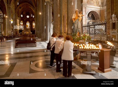 Women lighting candles in the Roman catholic church of Santa Maria ...