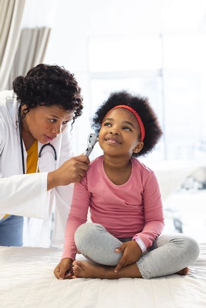 Premium Photo African American Female Doctor Examining Girl Patient