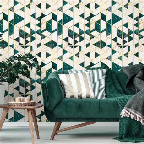 A Green Couch Sitting In Front Of A Wall With Geometric Tiles On It And