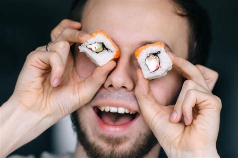 Homem feliz de entrega de sushi come sushi comida tradicional no japão