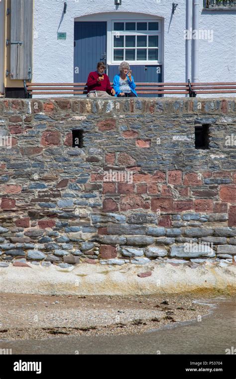 A Couple Enjoying An Ice Cream Sat On A Bench At The Harbour At The