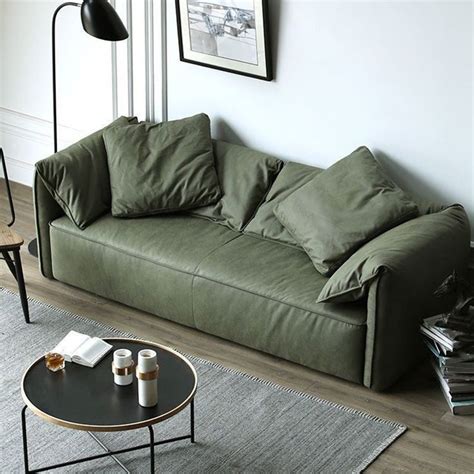 a living room with a green couch and coffee table in front of the wall,