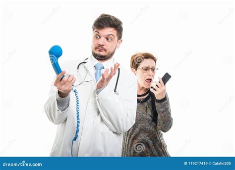 Female Senior Patient Screaming At Male Doctor To Telephone Stock Image