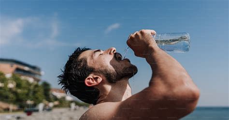 A man drinking water from a bottle on the beach photo – Water drink Image on Unsplash