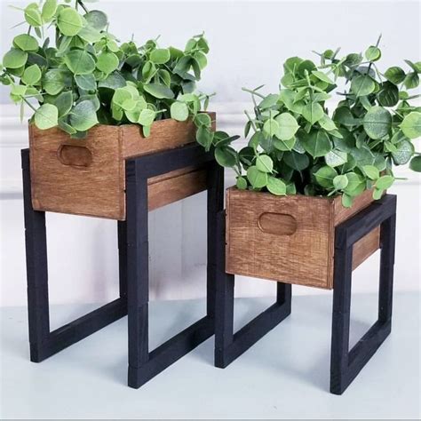 Two Wooden Planters With Green Plants In Them