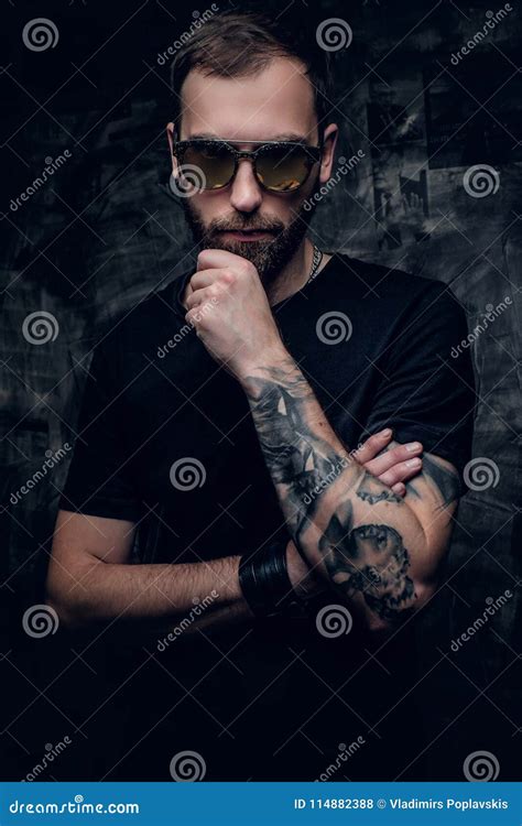 Un Hombre En Gafas De Sol Con El Tatuaje En Su Brazo Foto De Archivo