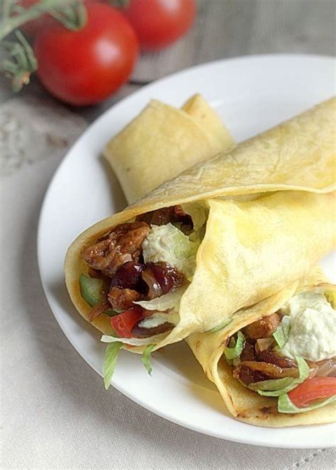 Two Burritos On A Plate With Tomatoes And Lettuce