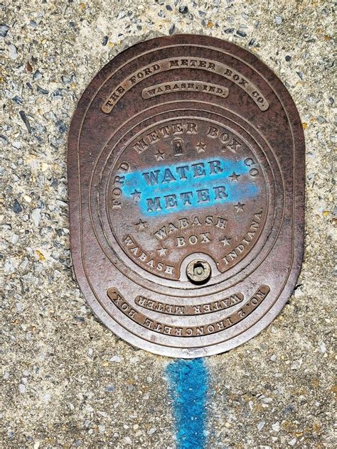 Metal Cover Of The Water Meter On The Sidewalk The Name Of The Company